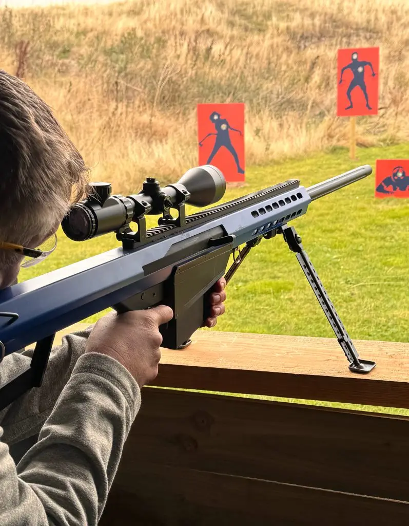 Participant aiming airsoft rifle at targets on Wild Cairns gun range