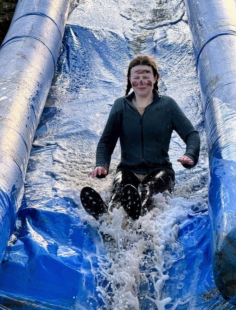 Participant sliding down large inflatable slide at Wild Cairns